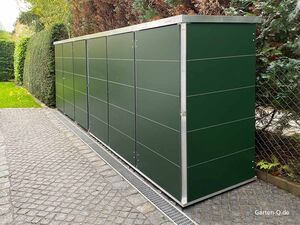 Grüner Gartenhaus, nebeneinander entlang eines Weges und Hecken im Hintergrund.