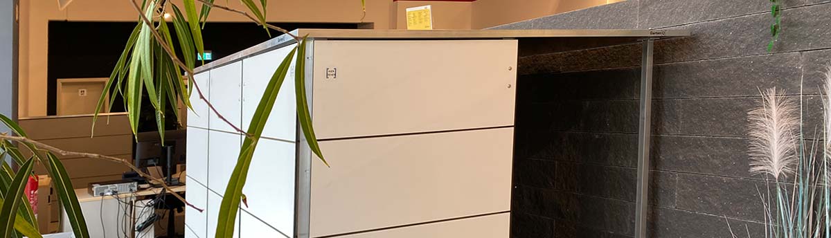 Ein Büro mit weißen Schränken, Pflanzen und einem schwarzen Hintergrund.